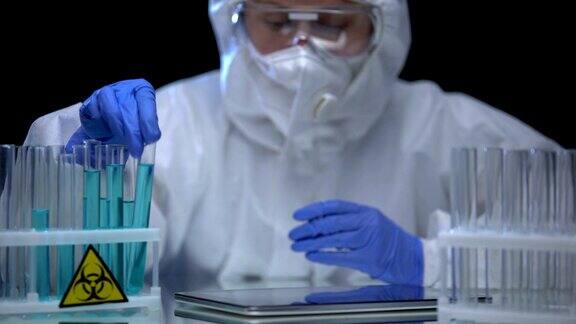 女性有毒实验室工作人员在药片上做笔记分析生物危害液体犯罪
