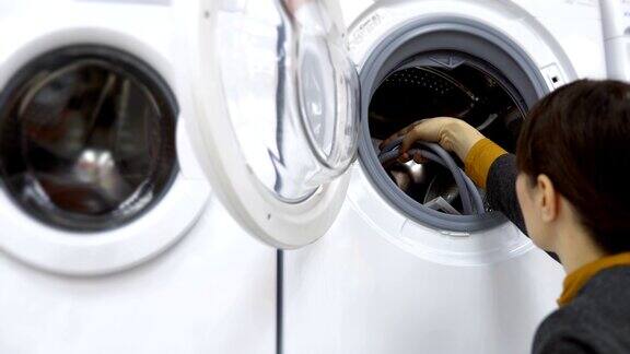 一位年轻的妇女在家电商店挑选一台洗衣机
