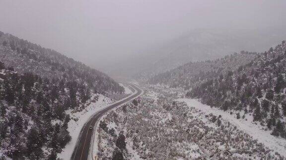 在暴风雪中无人机在山路上空飞行