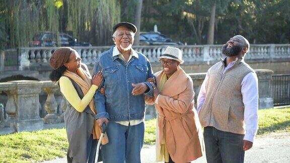 一个年长的非裔美国人和家人在公园散步