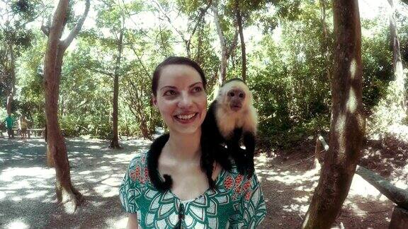 一个开心的女人肩上扛着一只猴子