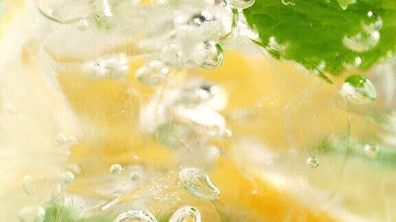 气泡挤过柠檬水成分的玻璃-微距镜头