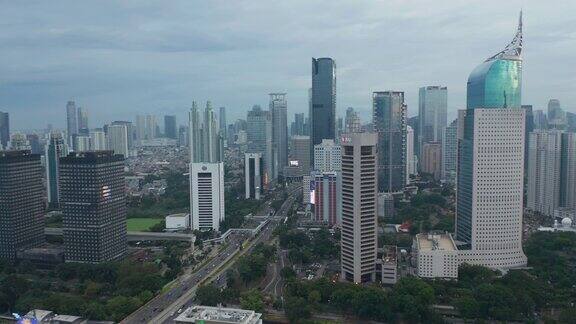 空中基座拍摄繁忙的城市交通驾驶在现代化的市中心与摩天大楼在雅加达印度尼西亚