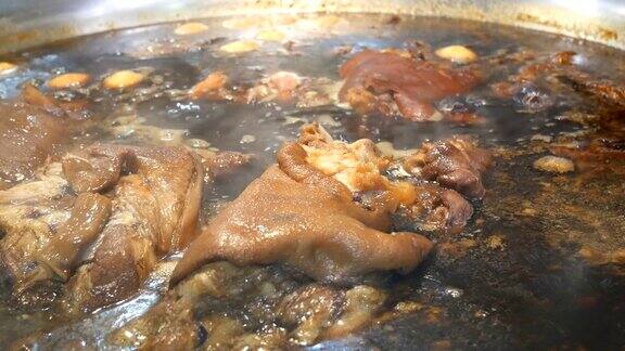 猪腿用热汤炖在一个大锅里配上一束香草