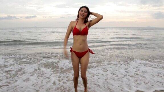 年轻美丽的亚洲女人在海滩摆姿势