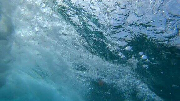 慢镜头水下:深蓝色的大海波涛破碎溅起水花