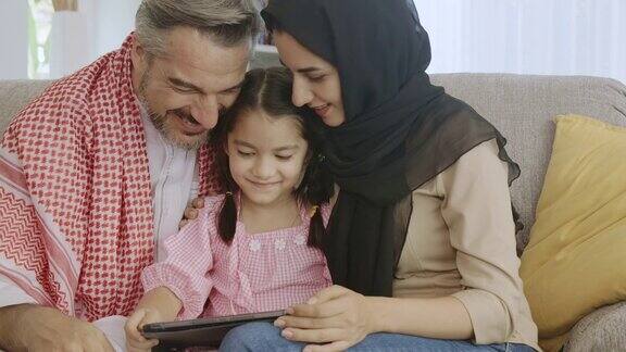 快乐的中东家庭享受一起看平板电脑快乐的时刻