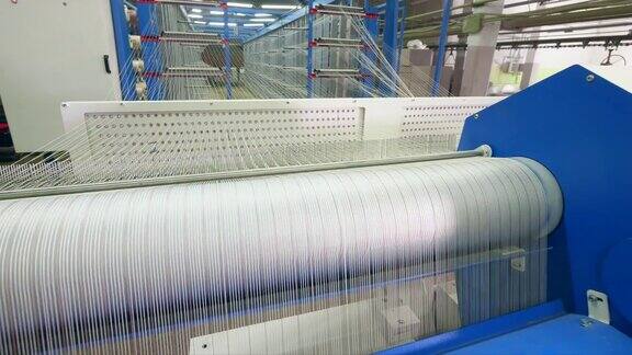 工厂的织机在设备室里织造白色纤维