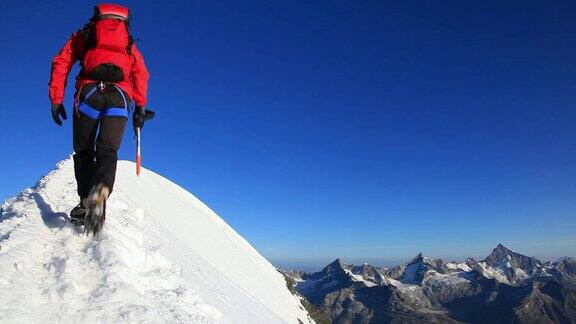 登山者沿着积雪的山脊行走HD1080p