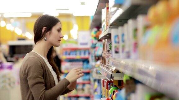 年轻女子在超市挑选婴儿玩具