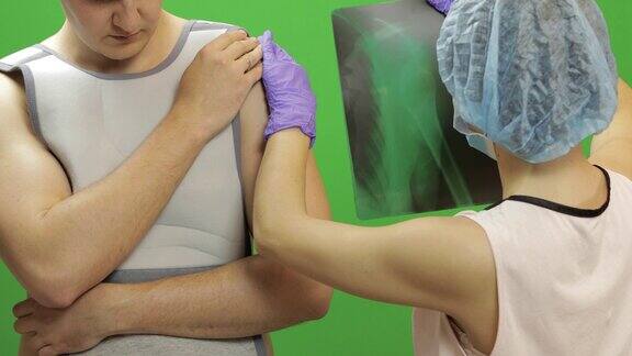 肩膀受伤的男人护士检查x射线肩部固定绷带