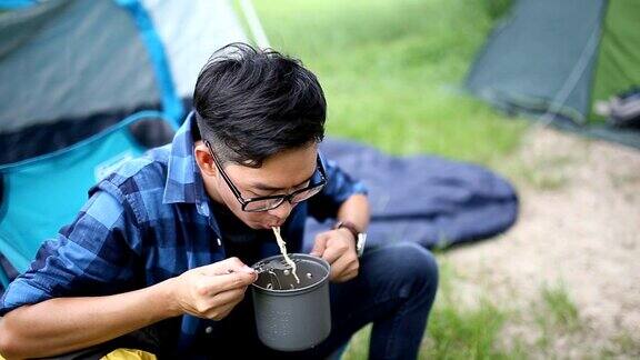 男人在野营时吃方便面全高清