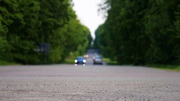 汽车行驶在乡村的道路上失去焦点4k的背景城市外的土路树木之间美丽的道路