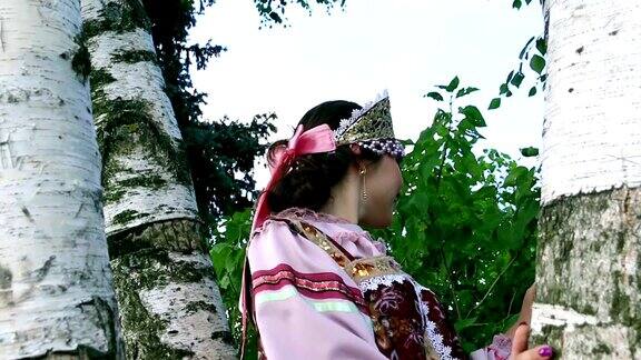 穿着民族服装的俄罗斯女孩梦想着桦树