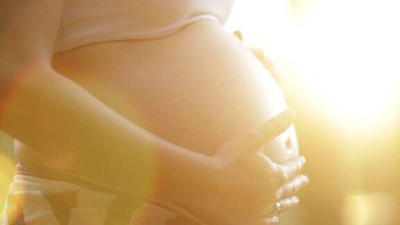孕妇在户外用镜头照明弹爱抚腹部夫人期待宝宝