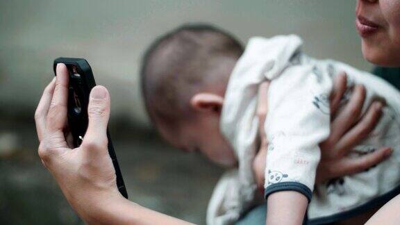 年轻的母亲和她的儿子使用智能手机