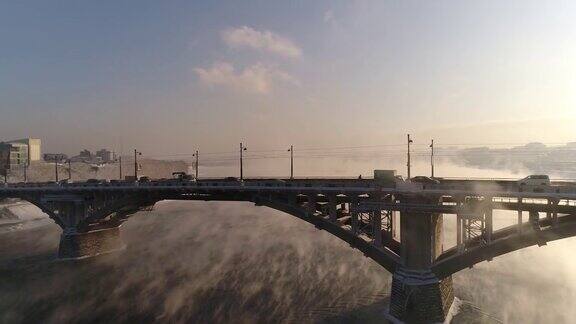安加拉河上的旧桥蒸汽从水中排出空中无人机飞行冬天这个俄罗斯城市被冰雪覆盖