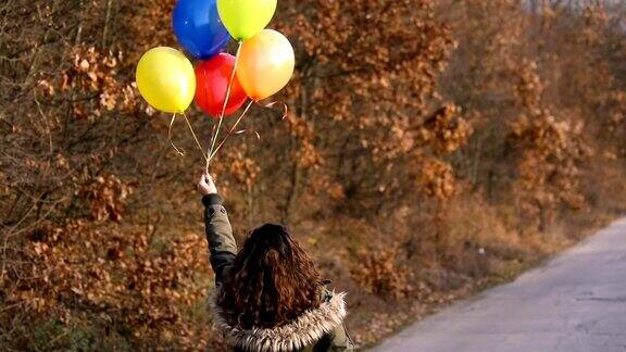 快乐的年轻女子与彩色气球