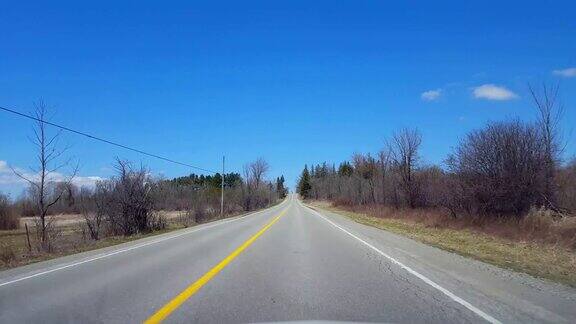 在春日驾驶乡村司机视角:沿着美丽的阳光乡村路