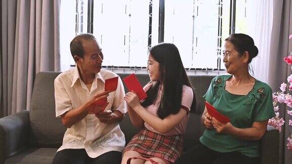 春节期间亚洲外孙女在客厅接受来自祖父母的春节红包