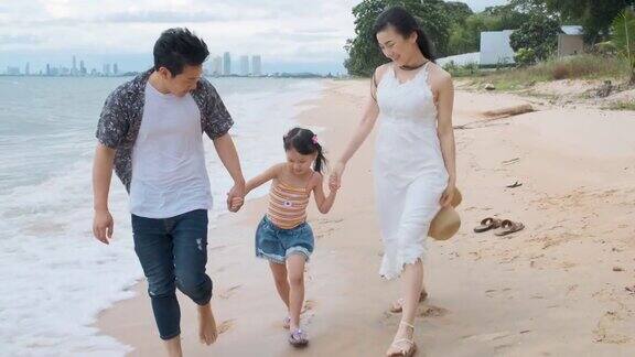 亚洲家庭与孩子在海滩散步快乐度假
