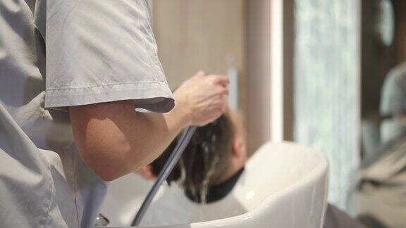 一位妇女在理发店里给顾客洗头