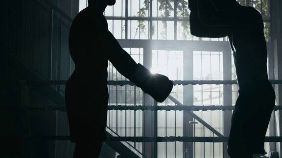 电影慢动作镜头的两个专业的年轻肌肉裸男拳击手战斗友好开始在拳击场