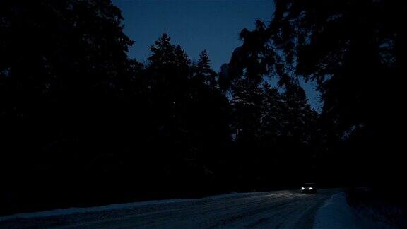汽车在夜晚行驶在冬季的道路上