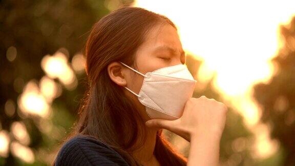 戴着空气污染口罩和橙色阳光咳嗽的生病妇女