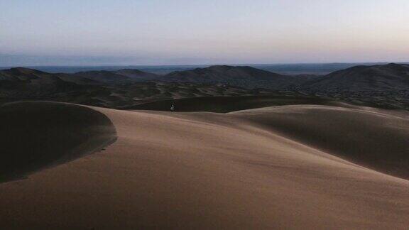一个摩洛哥人走在摩洛哥风大的沙漠里