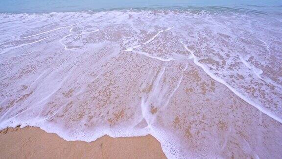 海浪擦去海滩文字在白色的沙滩上写在早晨热带的海滩美丽的白色沙滩和海浪在沙滩上撞击