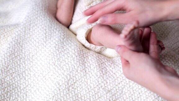 宝宝的脚按摩新生儿的脚在母亲的手中