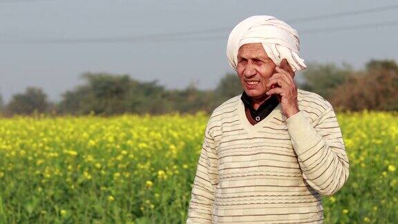 快乐的农民在芥菜田附近用手机聊天