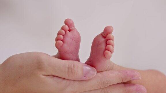 母亲用手托着婴儿小脚特写
