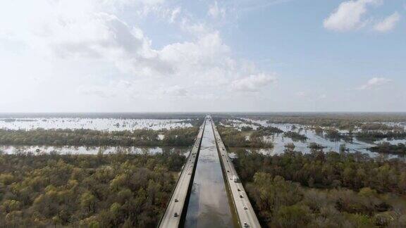 无人机拍摄的布鲁桥(10号州际公路)和Atchafalaya河流域沼泽包围柏树林在路易斯安那南部在一个阳光明媚但部分多云的天空