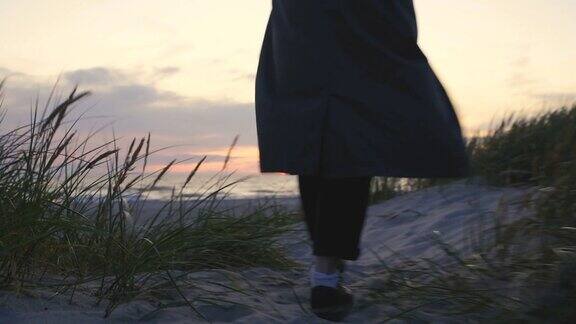 日落时分一个女人走在海滩上