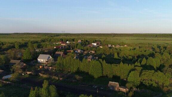 无人机航拍视频全景村庄的房子和花园在一条河上被茂密的绿色森林包围令人惊叹的风景电影的观点室外自然气候概念