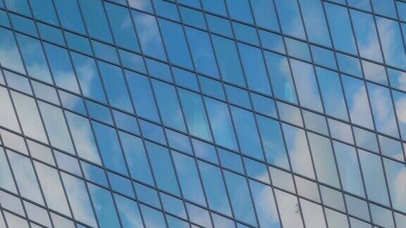 时间流逝-摩天楼玻璃墙上移动的白云的反射
