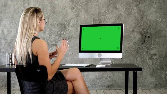 视频通话会议聊天通信概念办公室里一位女士在电脑上和别人聊天绿屏模拟显示