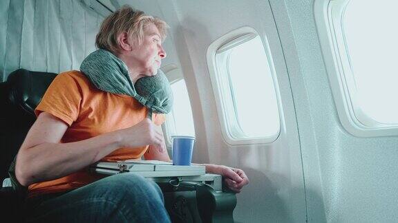 55岁的成熟女性在飞机上望向窗外