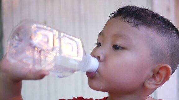亚洲男孩喝瓶子里的水