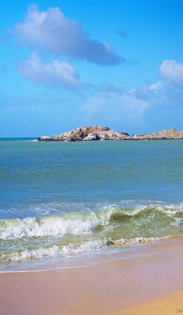 在热带岛屿海滩上破浪金色的沙滩和蓝绿色的海水