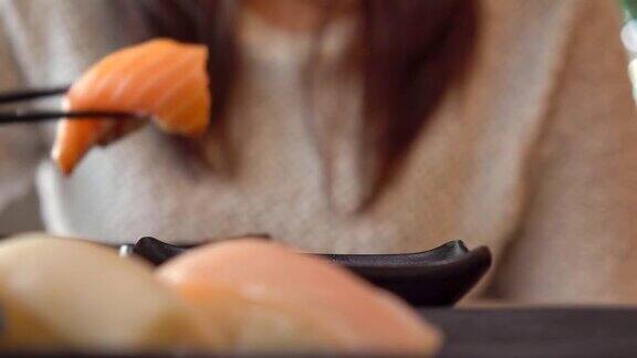 在餐馆吃日本寿司的女人