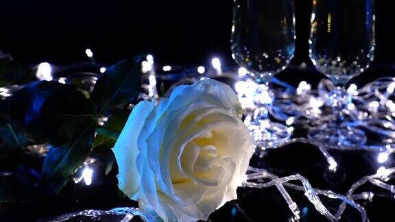 香槟杯和以鲜艳花环为背景的玫瑰