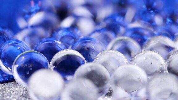 在蓝色和银色表面旋转的水凝胶球关闭宏