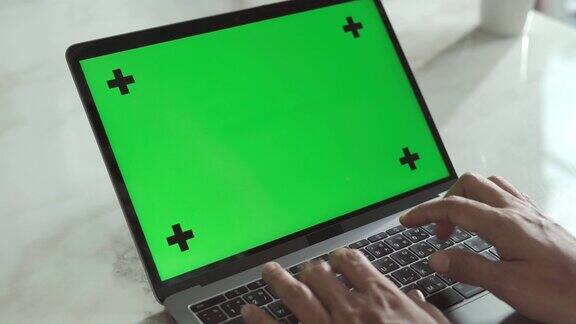 年轻人使用绿色屏幕色度键的笔记本电脑