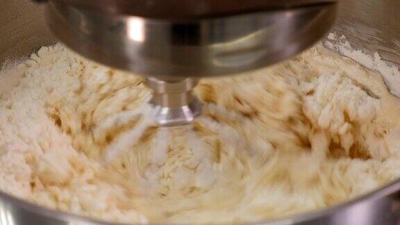 食品加工机在碗里搅拌面团原料的特写镜头