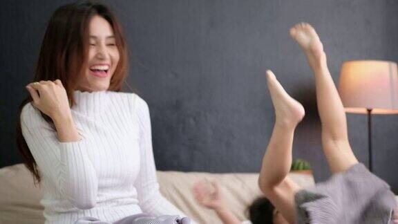 母亲和女儿一起在床上蹦蹦跳跳玩得开心家庭时间的幸福理念