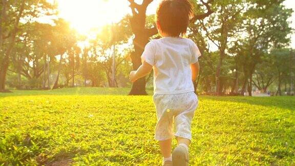 日落时分小男孩在公园里跑步