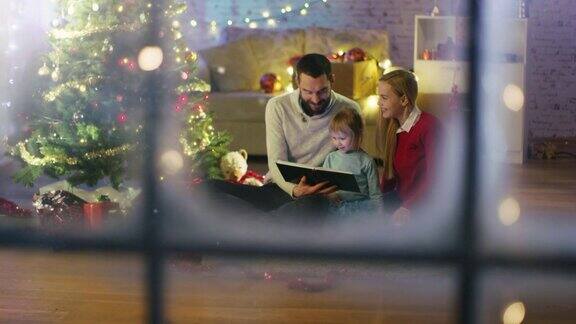 看窗外爸爸和妈妈给小女儿读一本书